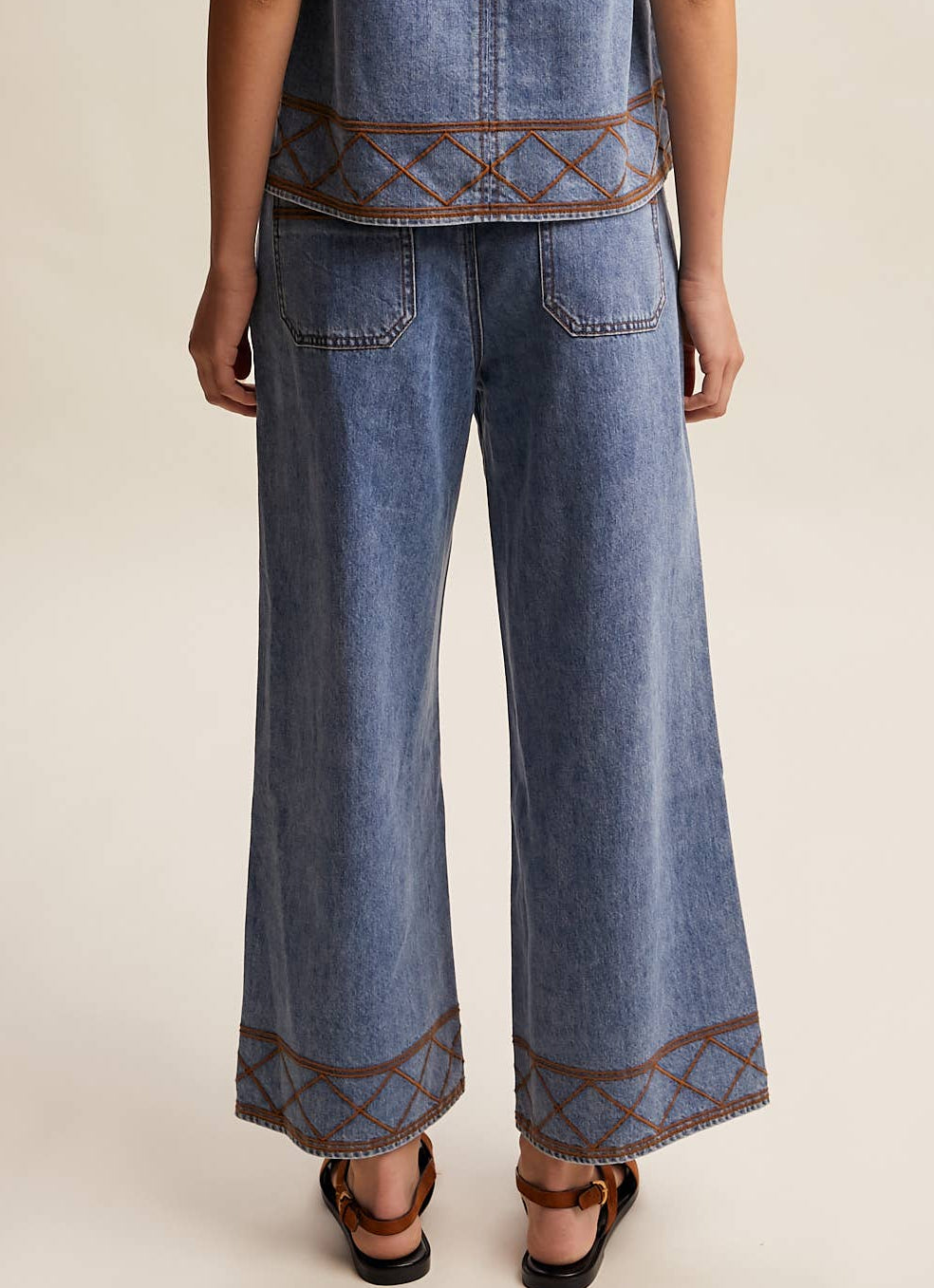 Woman wearing a denim outfit with a plain background